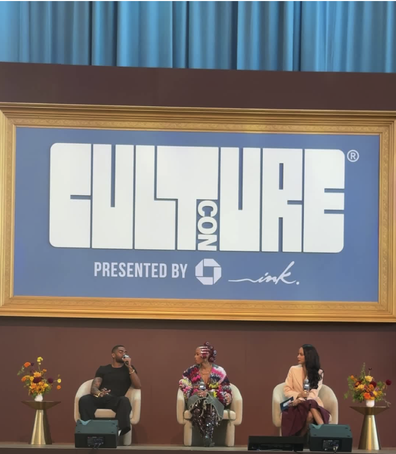 Panel of three speakers seated on stage beneath the Culture Con sign