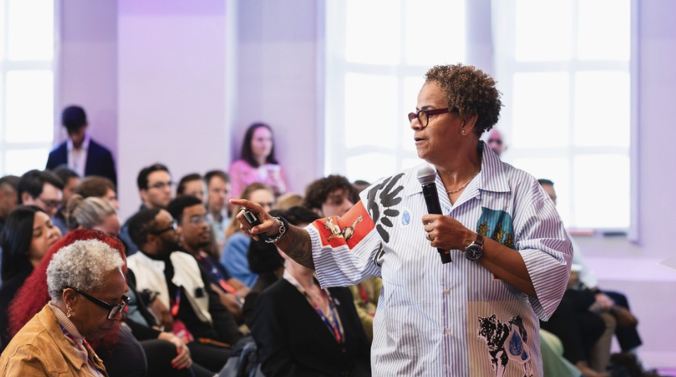 Melissa Bradley speaking with a microphone to a seated audience at DC Start Up & Tech Week